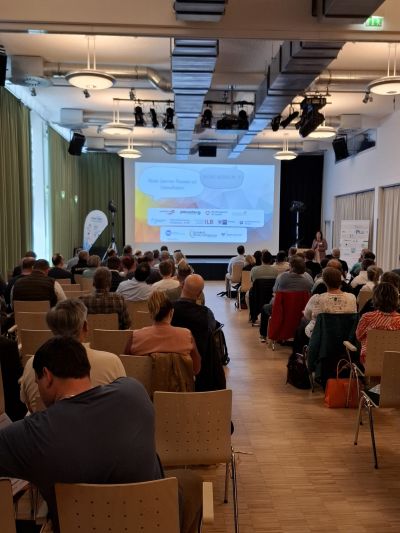 Personen nehmen an einem Vortrag zum Thema: "Treffpunkt Wirtschaft PM+ TF" teil