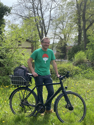 Mann mit Fahrrad auf Wiese