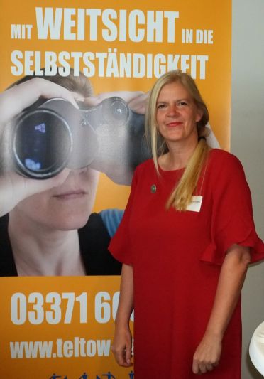 Steffi Weit vor Plakat mit Aufschrift