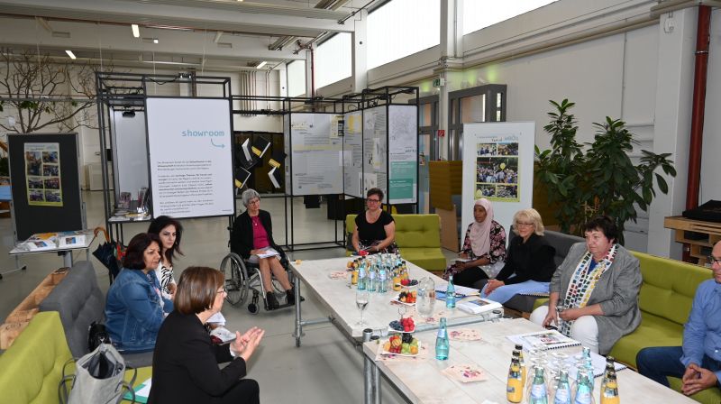 Personengruppe am Tisch im Gespräch mit Ministerin, Landrätin, Bürgermeisterin