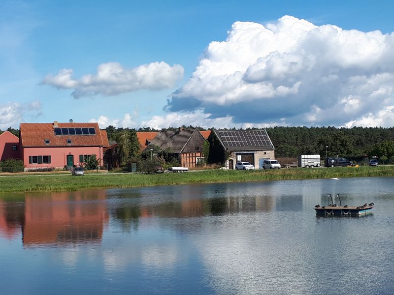 Dorfteich Groß Ziescht mit Blick auf mehrere Häuser, darunter das älteste Bauernhaus Brandenburgs