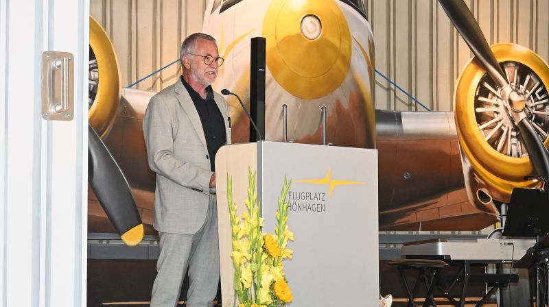 Auf der Bühne am Pult hält Dr. Klaus-Jürgen Schwahn seine Ansprache auf der Festveranstaltung